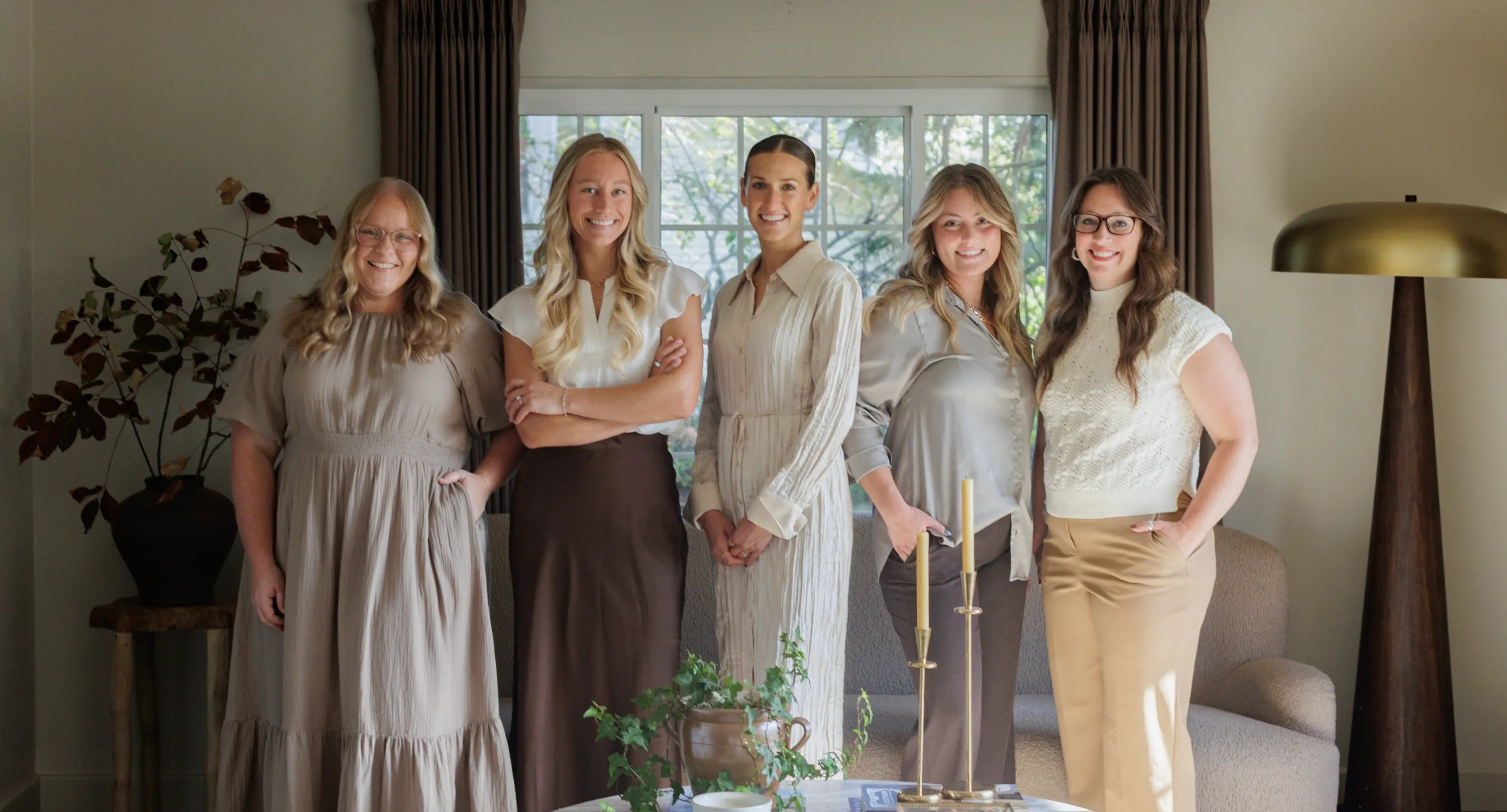 S. Flynn Home team featuring the founder Sadie in the middle, accompanied by her store managers and marketing associates, in a styled living room showcasing S. Flynn Home products. 