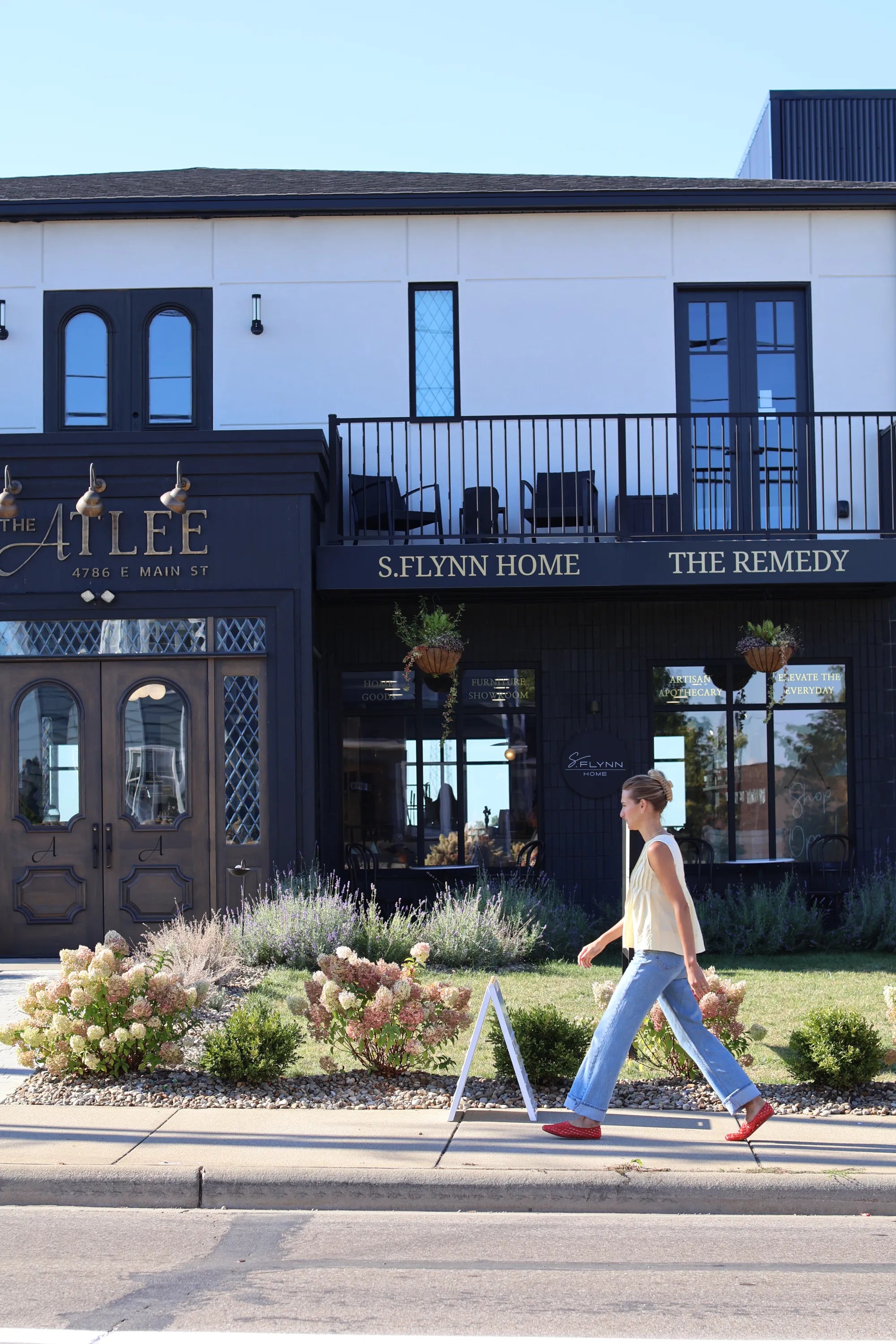 Founder of S. Flynn Home, walking in front of the S. Flynn Home store location, Atlee.